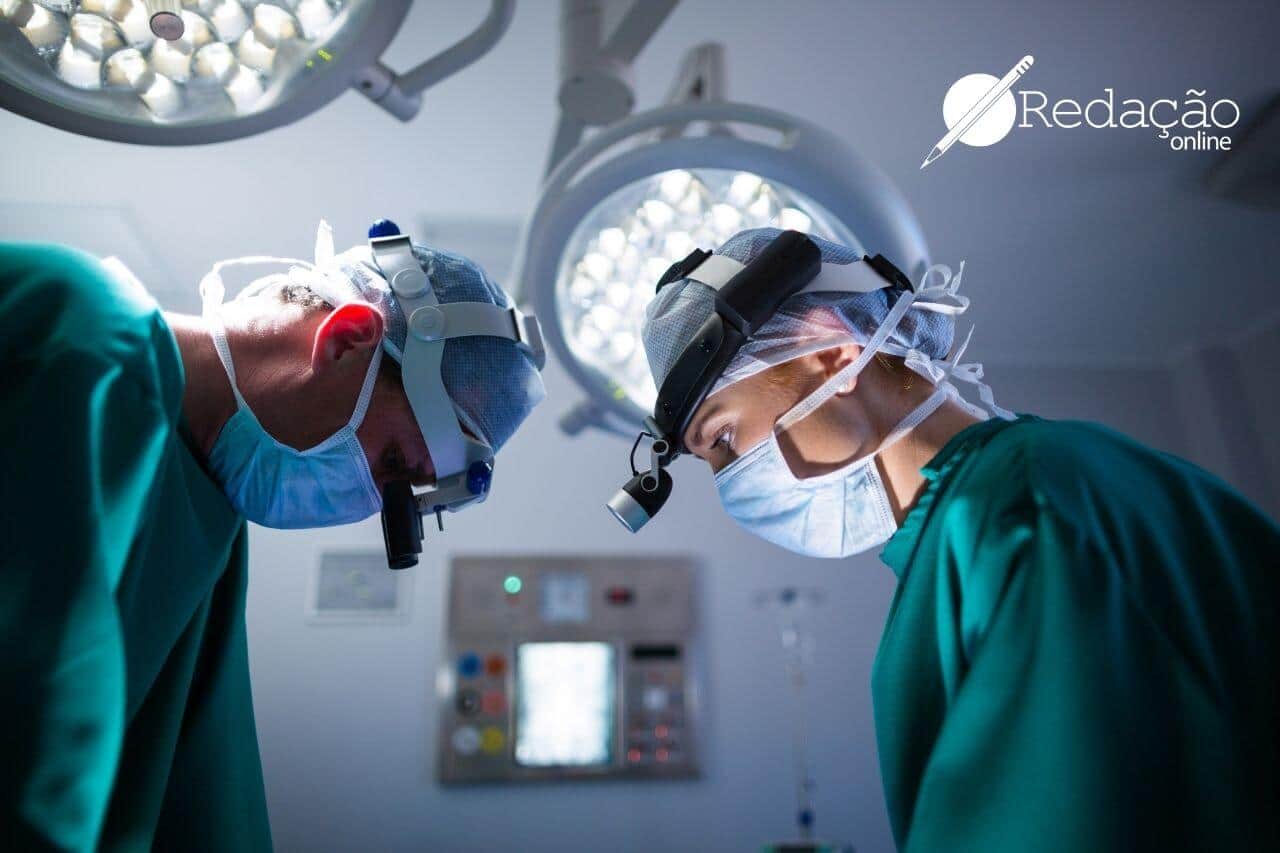 dois médicos fazendo cirurgia com jaleco verde