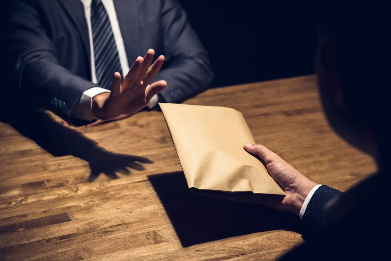 homem entrega envelope a outro com proprina demonstrando o jeitinho brasileiro e corrupção