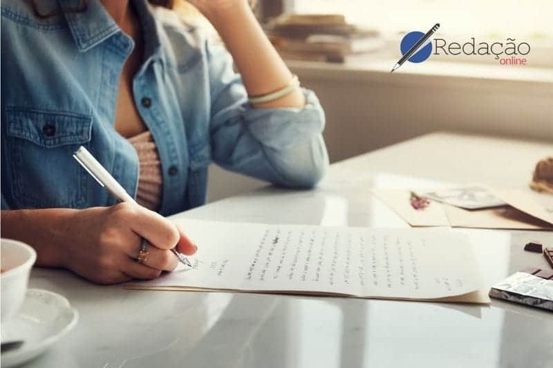 Imagem de uma mulher escrevendo em um papel com caneta